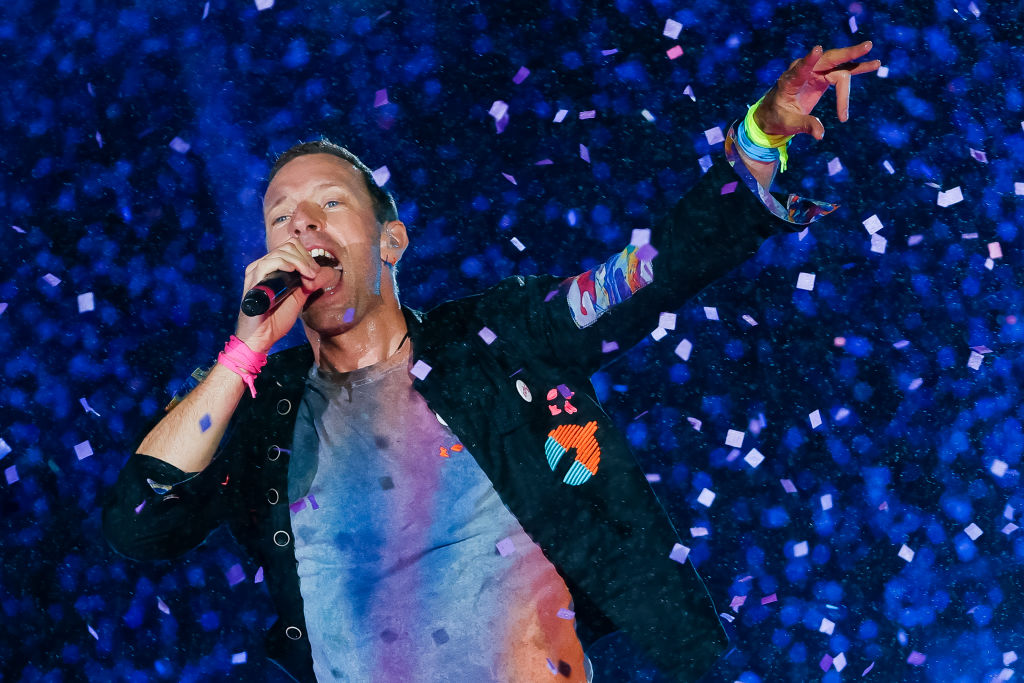 Chris Martin singing with hand in air
